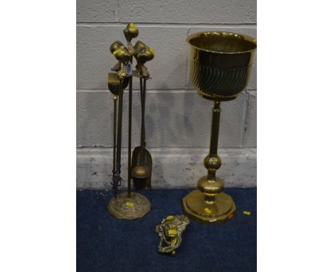 A BRASS FOUR PIECE COMPANION SET with ball and claw detail on a matching stand, together with a brass planter on a stand and 
