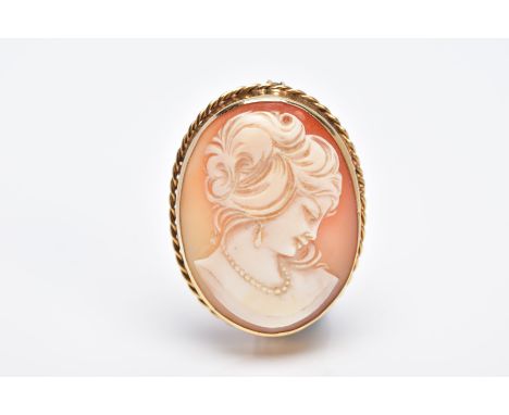 A 9CT GOLD CAMEO BROOCH, of an oval design, the cameo depicting a lady in profile within a collet mount and rope twist surrou