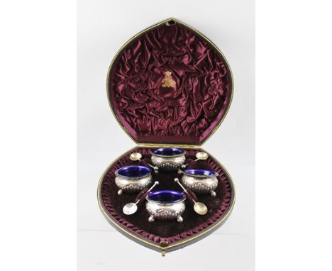 ELKINGTON & CO A SET OF FOUR VICTORIAN SILVER SALTS each hemispherical with three ball feet and blue glass liner and a matchi