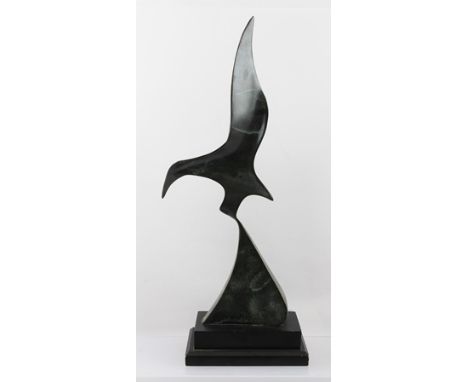 A 20TH CENTURY BRONZE SCULPTURE OF A STYLISED BIRD IN FLIGHT, partial green patination, raised on an ebonised plinth base, ov