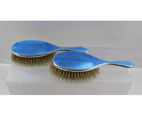 ** CO. A PAIR OF SILVER BACKED BLUE ENAMEL AND ENGINE TURNED LADY'S HAIR BRUSHES with geometric star burst decoration, London