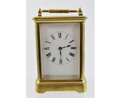 A FRENCH BRASS CASED CARRIAGE CLOCK, hinged handle, bevel plate glass panels, white enamel dial with Roman numerals, the back