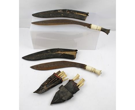 TWO KUKRI KNIVES with bone handles and additional tools, in leather scabbards 