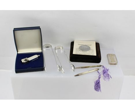 A MIXED LOT OF SILVER COLLECTABLES to include; a 100g ingot paperweight, an engine turned decorated cigar lighter, a commemor