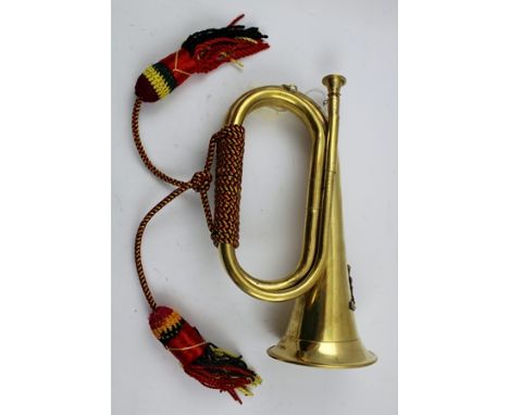 A BRASS MILITARY BUGLE with crest for the Royal Artillery, with cord 