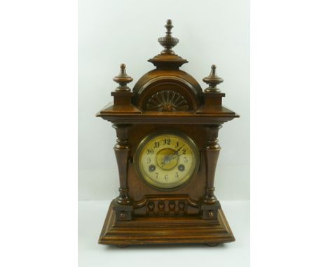 A 20TH CENTURY JUNGHANS WALNUT FINISHED MANTEL CLOCK having carved and moulded case with knops and finials, eight day spring 