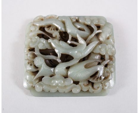A GOOD CHINESE MING DYNSTY OR LATER CARVED JADE PLAQUE, carved to depict a dragon dog amongst swirling clouds and flora, 7cm 