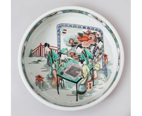 A LARGE CHINESE KANGXI STYLE FAMILLE VERTE PORCELAIN DISH, the centre of the dish depicting figures playing a game beside a s