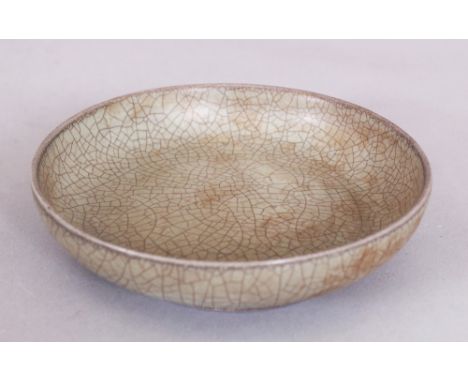 A CHINESE SONG STYLE GUAN WARE CERAMIC DISH, applied with an olive-green crackle glaze, 5.5in diameter.