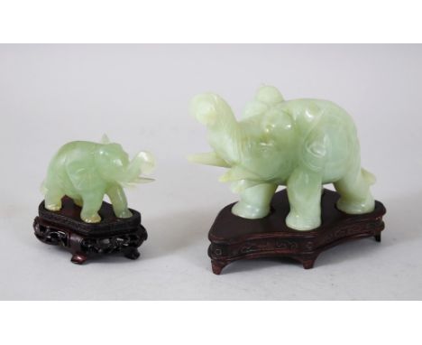 TWO 20TH CENTURY CHINESE JADE ELEPHANT FIGURES WITH BASES,  each elephant in a striding pose and coupled with a fitted carved