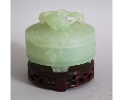 A 20TH CENTURY CHINESE JADE CYLINDRICAL POT AND COVER, the pot with four scroll feet, chased panelled floral decor, the lid w
