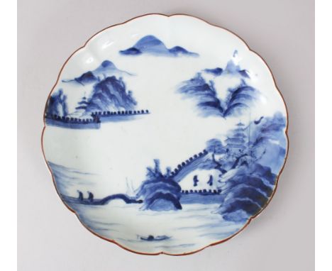 A JAPANESE EDO PERIOD ARITA BLUE &amp; WHITE LOBED PORCELAIN DISH, with decorations  mountains, temples amongst lakeside sett