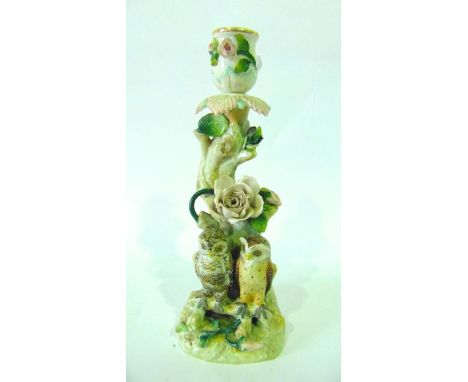 A 19th century continental candlestick in the form of a floral encrusted tree trunk with applied figures of a pair of owls, w