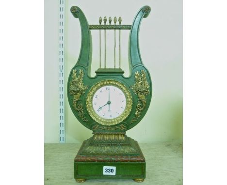 A 19th century mantel clock in the Regency style with lyre shaped framework and applied gilt brass cornucopia, enclosing a co