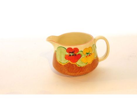A Clarice Cliff Bizarre jug with painted nasturtium decoration in orange, yellow and green above a speckled brown ground with