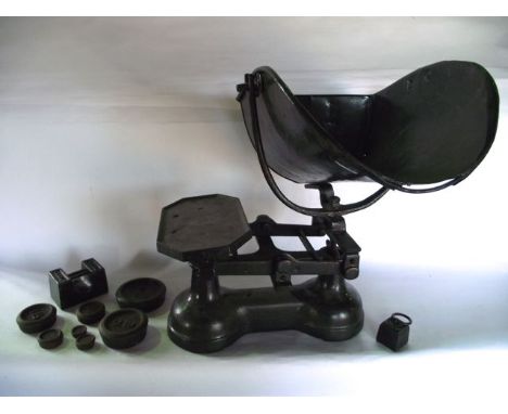 A substantial cast iron commercial scale set with all over blackened finish, removable basket and associated graduated iron w