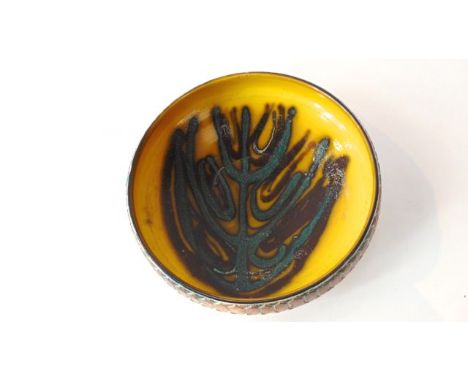 A Poole Pottery yellow ground bowl with painted stylised plant motif to the interior, with incised decoration to the exterior