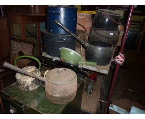 A 19th century cast iron pot bellied cauldron with loop handle and tripod supports together with various cast iron saucepans 