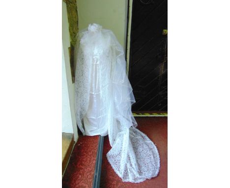 A 1960s empire line white satin wedding dress with accompanying long sleeved lace coat and train, together with a veil and he