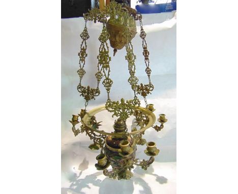 A brass framed ceiling light supporting a pair of three armed candle sconces with a central electronic conversion, with folia