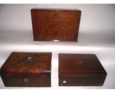 A Victorian burrwood veneered travelling box with domed hinged lid with inlaid vacant mother of pearl cartouche and lock escu