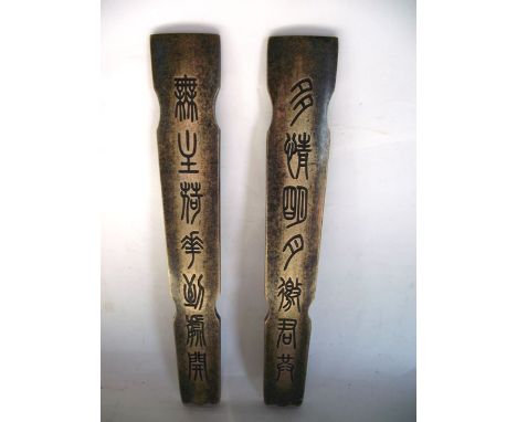 A pair of Chinese cast metal scroll tablet weights of shaped rectangular form, each with seven archaic Chinese characters wit