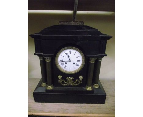 A Victorian black slate mantel clock with column supports and applied brass detail, with 8-day striking movement