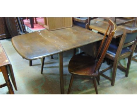 An Ercol dark stained elm and beechwood drop leaf kitchen table raised on four square tapered and splayed legs together with 