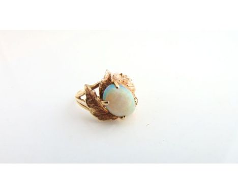 An opal ring, the central oval cabochon opal weighing approximately 2.13cts, with textured leaf border, in 10ct gold, size P