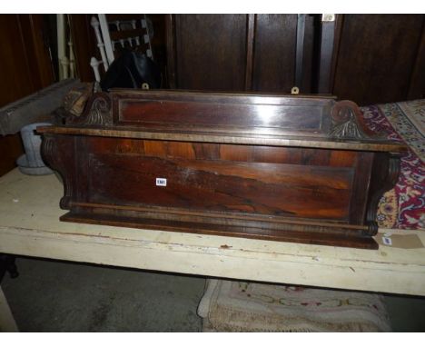 A 19th century rosewood veneered wall shelf, with panelled back, flanked by scrolled brackets