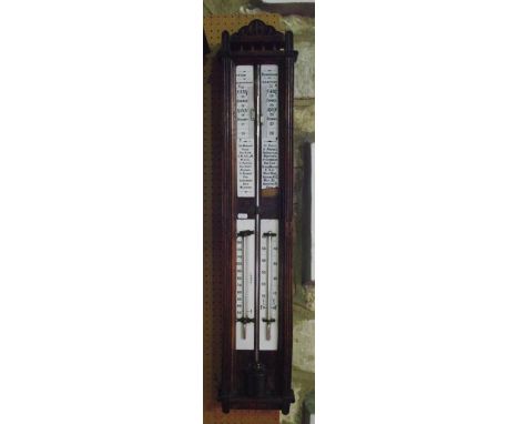 A 19th century stick barometer set within a reeded and carved oak framework with enamelled dials for centigrade and farenheit