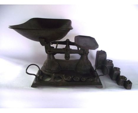 A vintage cast iron set of domestic scales together with associated graduating squared and disc shaped weights