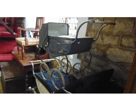 A vintage Marmet coach built pram with black and cream painted livery, sprung frame and wire spoke wheels with hard rubber ty