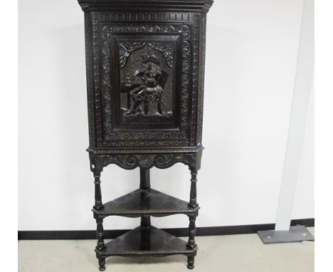 A stained oak carved 20th century corner cupboard on stand, top section having a moulded cornice, single panelled door with c