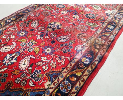 Woollen floral and paisley patterned runner, on a light red ground, 77cm x 300cm