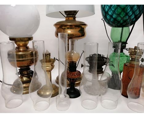 A quantity of various 20th Century oil lamp bases,  shades, reservoirs and glass chimneys, to include a bulbous green glass s