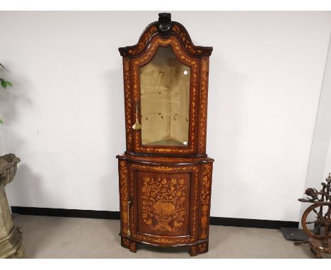 A mahogany marquetry corner cabinet,  heavily detailed in a Dutch style, with single glazed door and three glass internal she