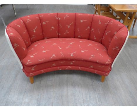A 1940's Danish curved 'Banana' two seater sofa, original red and white floral upholstery, stained beech short legs. 160cm x 