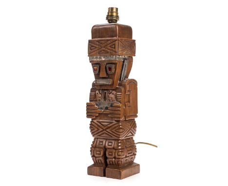 *Peru. A hardwood table lamp carved as a traditional Peruvian figure,  with red enamel eyes and white metal mounts, 36cm high