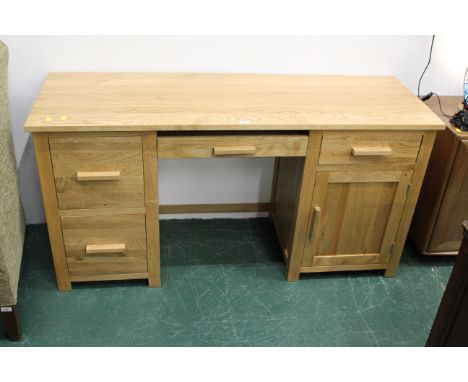 Modern light oak desk with central keyboard drawer, 2 drawers to left and drawer with cupboard to right