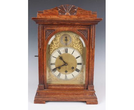 An early 20th century German oak mantel clock with eight day movement chiming on gongs, the backplate detailed 'Gustav Becker