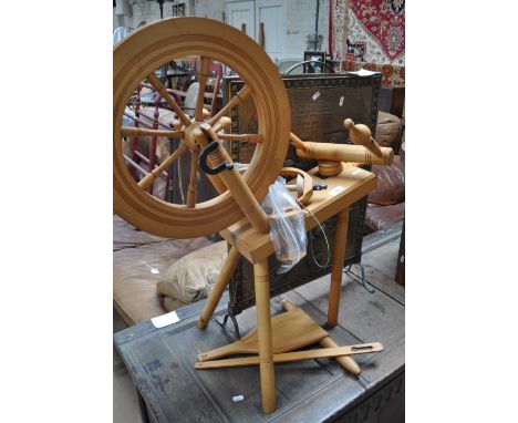 A modern beech spinning wheel and a brass firescreen.
