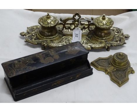 An embossed cast brass desk stand with 2 inkwells and an inkwell and a black lacquered desk stand.