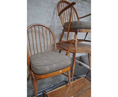 A pair of low Ercol Windsor stick back elbow chairs with blue labels, (335,305?)and a circular Ercol elm top coffee table.