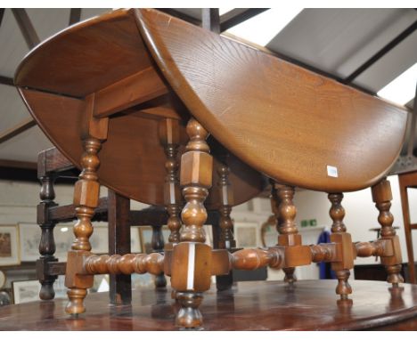 An Ercol bow end drop leaf occasional table on turned legs, length 105cm, height 49cm.