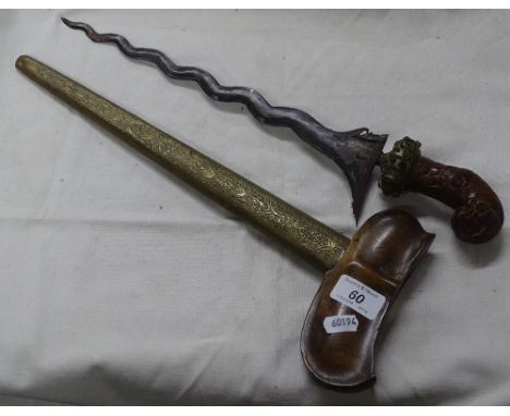 A Kris with carved wood stone set handle and embossed brass scabbard.