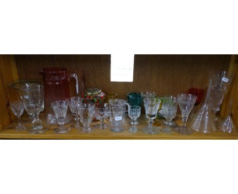 A shelf of glassware and a clock.