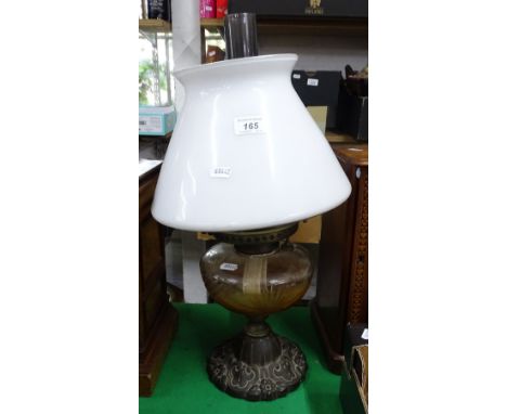 An oil lamp with cut-glass font and milk glass shade.