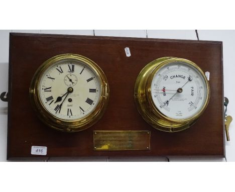 A brass bulk head clock and barometer mounted on wall plaque with brass presentation plaque dated 1967.