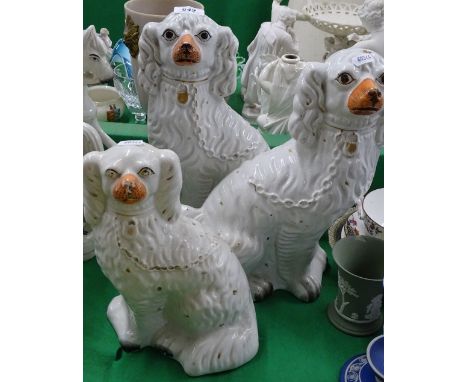 A pair of Edwardian Staffordshire mantel spaniels and another.